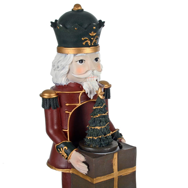 Close up of a nutcracker soldier holding a gift and Christmas tree