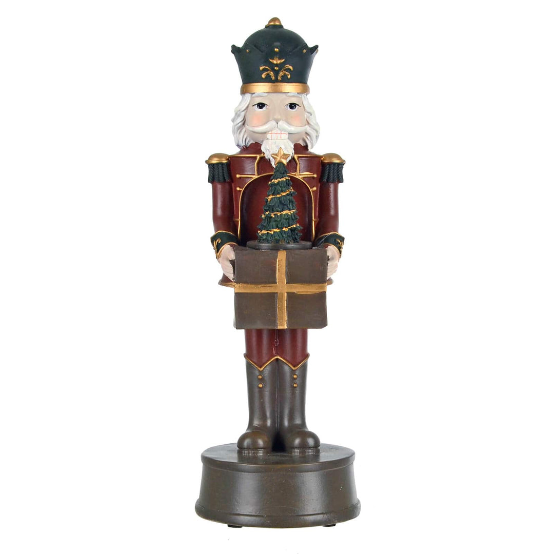 Christmas nutcracker figure holding a gift and Christmas tree