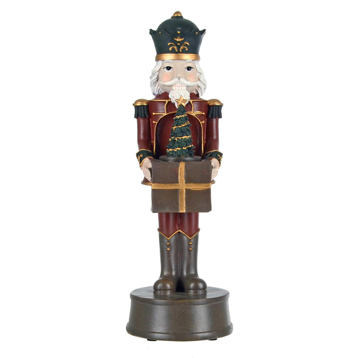 Christmas nutcracker figure holding a gift and Christmas tree