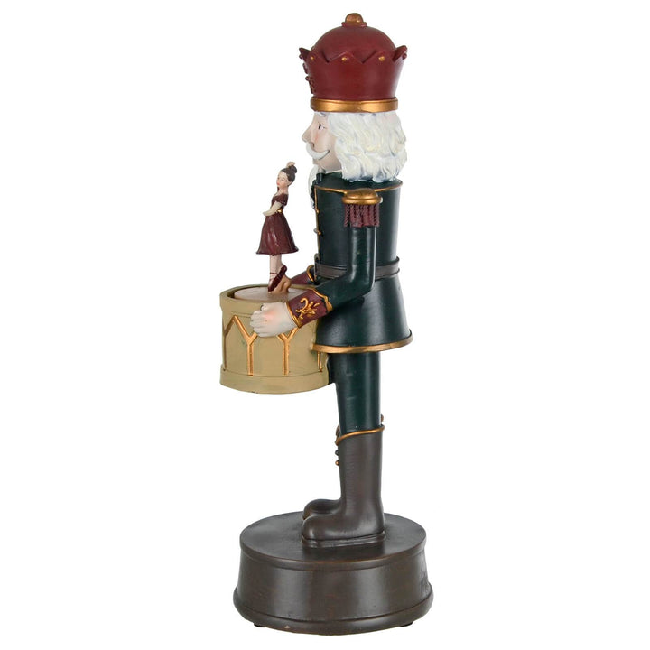 Side view of a Nutcracker figure holding a drum with ballet dancer