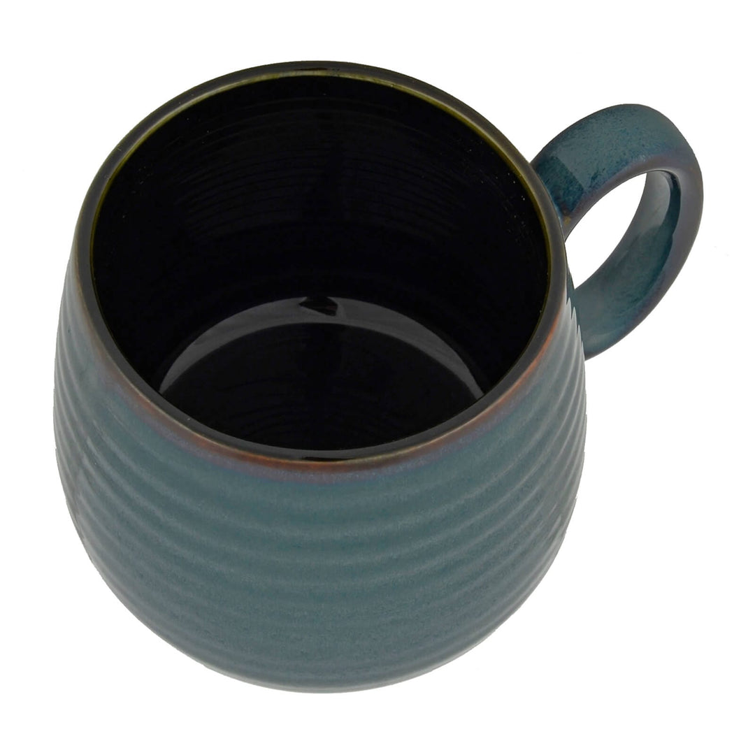 Overhead view of a dark turquoise coffee mug with large handle