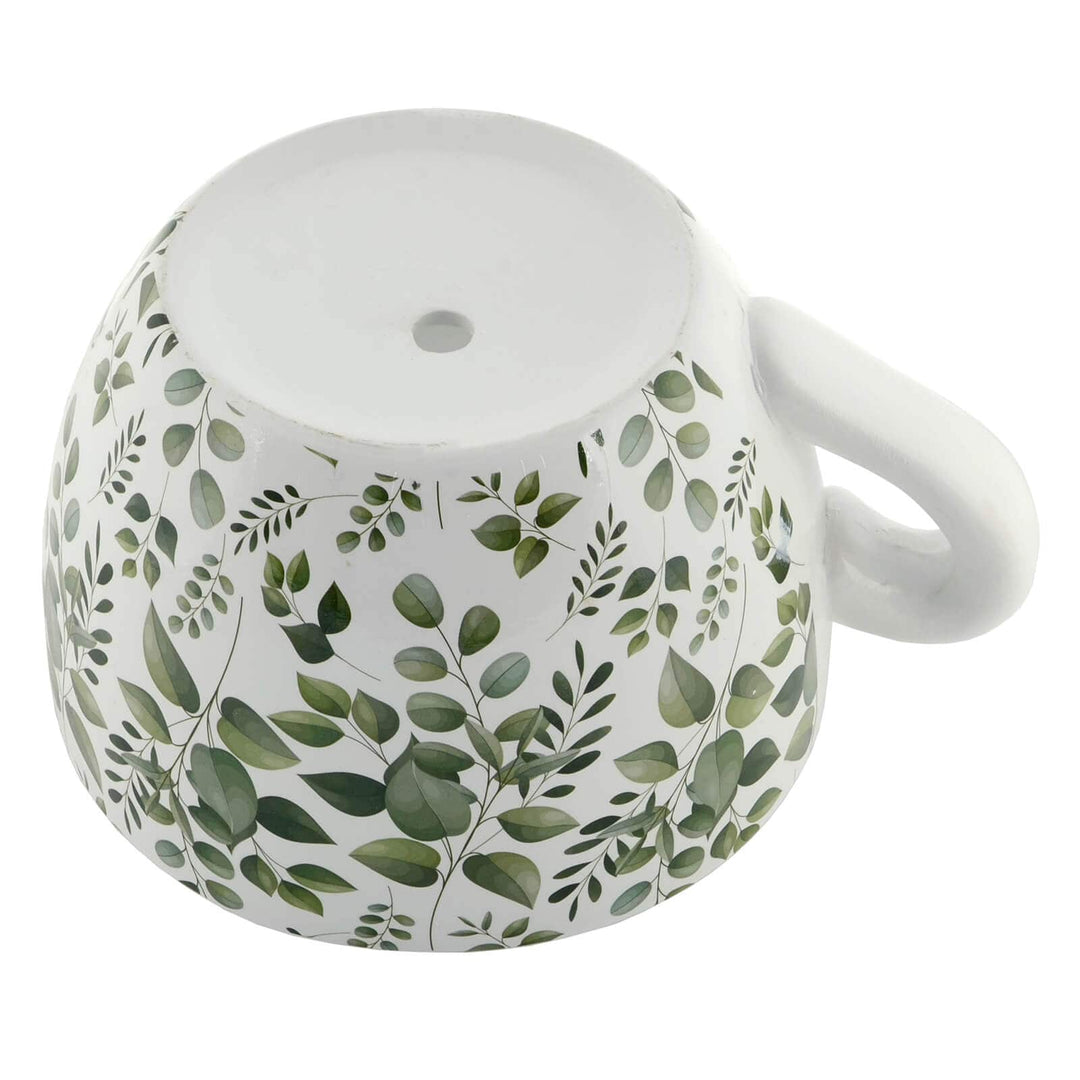 Base of a teacup flower planter with drainage hole and eucalyptus leaves pattern