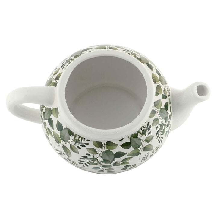 Overhead view of a white ceramic teapot planter with leaf pattern