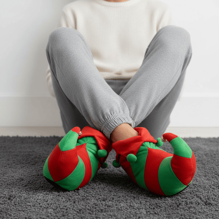 Person wearing red and green caterpillar-shaped slippers on a gray carpet.