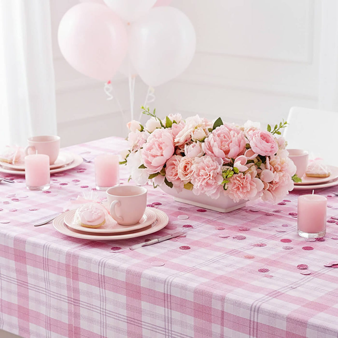 Decorative table setting with pink flowers, checkered tablecloth, and balloons.