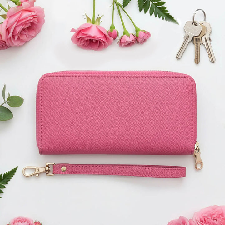 Pink purse with a wrist strap, keys, and pink roses on a white background